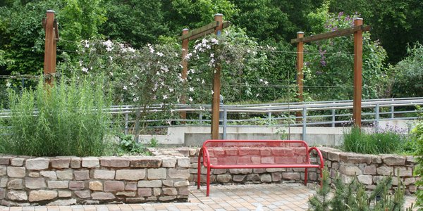 Rote Sitzbank im Garten der Sinne des Seniorencentrums