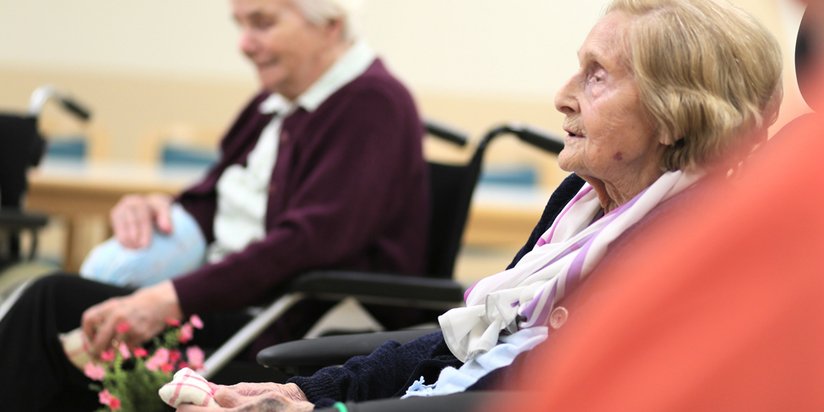 Blick auf zwei ältere Damen im gemeinsamen Stuhlkreis