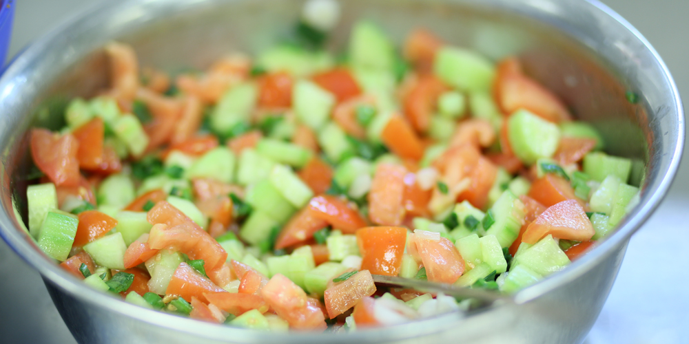 Salatschüssel gefüllt mit frischem Salat, Tomaten und Gurken